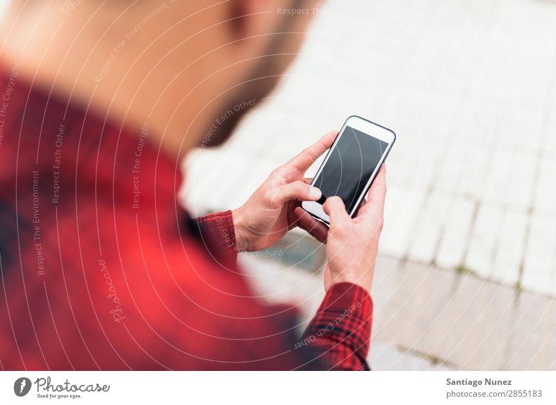 Junger Mann benutzt sein Handy auf der Straße. Mobile Porträt Glück Lächeln Telefon Schickimicki Lifestyle stehen benutzend Großstadt Solarzelle Stadt Mensch