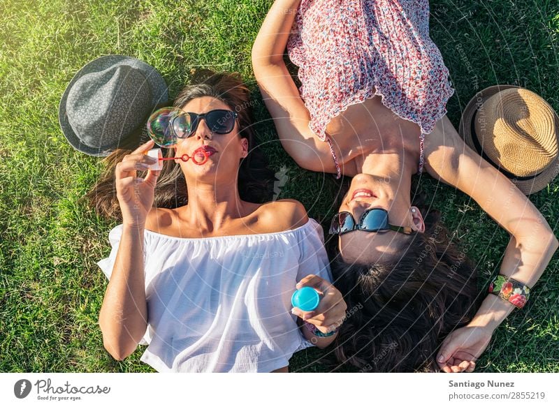 Fröhliche Mädchen beim Spaß im Park. Freundschaft Frau Glück Luftballon hübsch Fröhlichkeit Luftblase Seife schön Freude Blase Lifestyle Mensch Gras Sommer