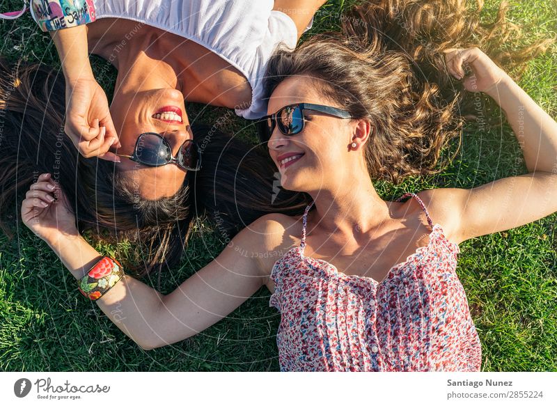 Fröhliche Mädchen beim Spaß im Park. Freundschaft Frau Glück hübsch lügen Fröhlichkeit schön Freude Lifestyle Mensch Gras Sommer Außenaufnahme Party Jugendliche