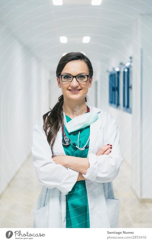 Lächelnd schöner Arzt im Krankenhaus. Stehend. Arme attraktiv Hintergrundbild Fürsorge Kaukasier heiter Klinik Klinikerin Gerät Frau Freundlichkeit