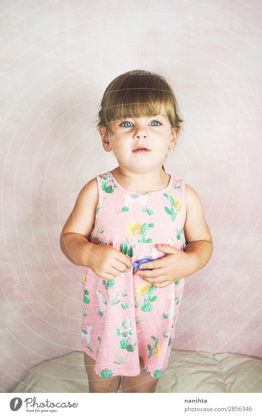 Junges kleines und lustiges Mädchen in einer Studioaufnahme Lifestyle Freude Glück Gesicht Leben Kind Baby Kleinkind Frau Erwachsene Kindheit Kleid blond