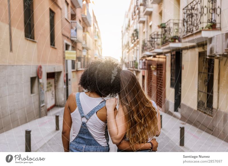 Rückansicht von jungen Frauen, die Spaß auf der Straße haben. Afro-Look Freundschaft Jugendliche Glück Sommer Porträt Mensch Freude Rassismus Erwachsene Mädchen