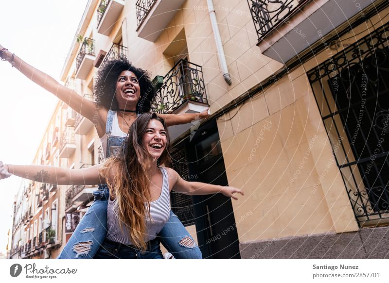 Schöne Frauen haben Spaß auf der Straße. Freundschaft Jugendliche Afro-Look Glück Huckepackverkehr Lächeln Sommer Mensch Freude laufen Mädchen hübsch schön 2