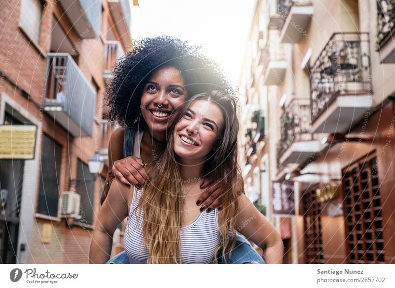 Schöne Frauen haben Spaß auf der Straße. Freundschaft Jugendliche Großstadt Glück Huckepackverkehr Lächeln Sommer Mensch Freude laufen Mädchen hübsch schön 2