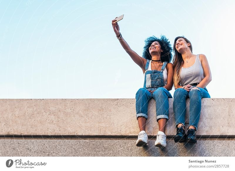 Wunderschöne Frauen, die ein Selbstporträt auf der Straße machen. Freundschaft Jugendliche Glück Sommer Mensch Freude Mobile PDA Telefon Solarzelle Fotografie