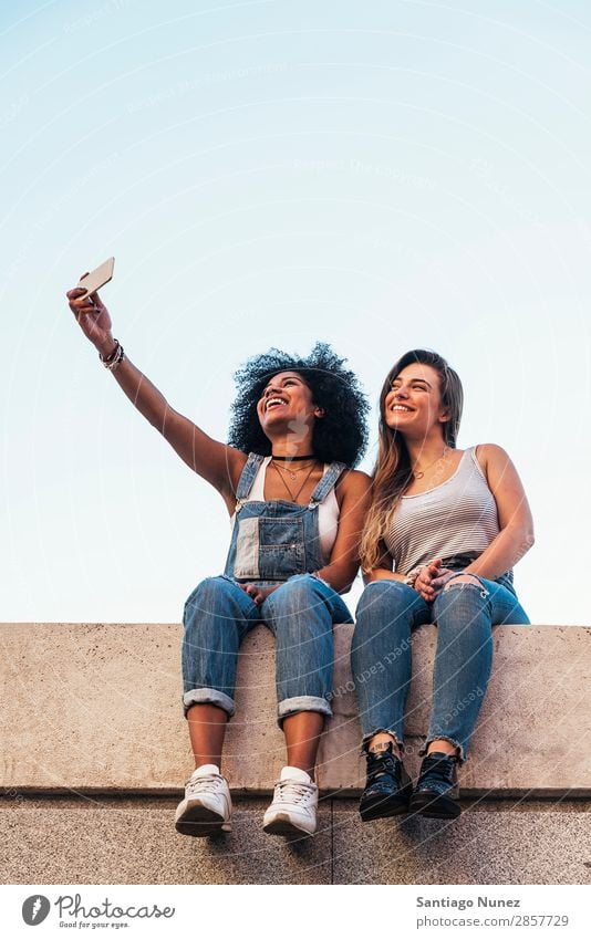 Wunderschöne Frauen, die ein Selbstporträt auf der Straße machen. Freundschaft Jugendliche Glück Sommer Mensch Freude Mobile PDA Telefon Solarzelle Fotografie