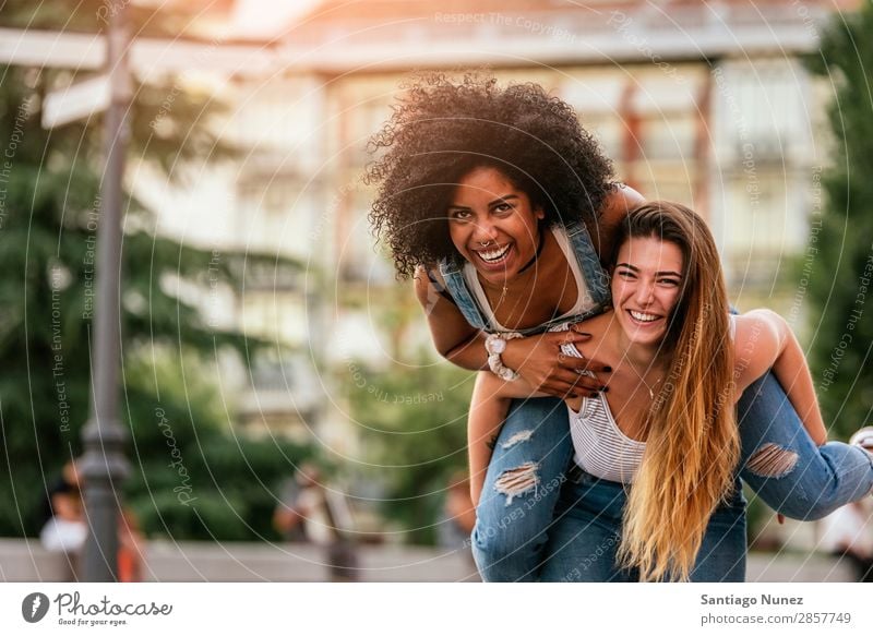 Schöne Frauen haben Spaß auf der Straße. Freundschaft Jugendliche Glück Huckepackverkehr Lächeln Sommer Mensch Freude laufen Mädchen hübsch schön 2 Zusammensein