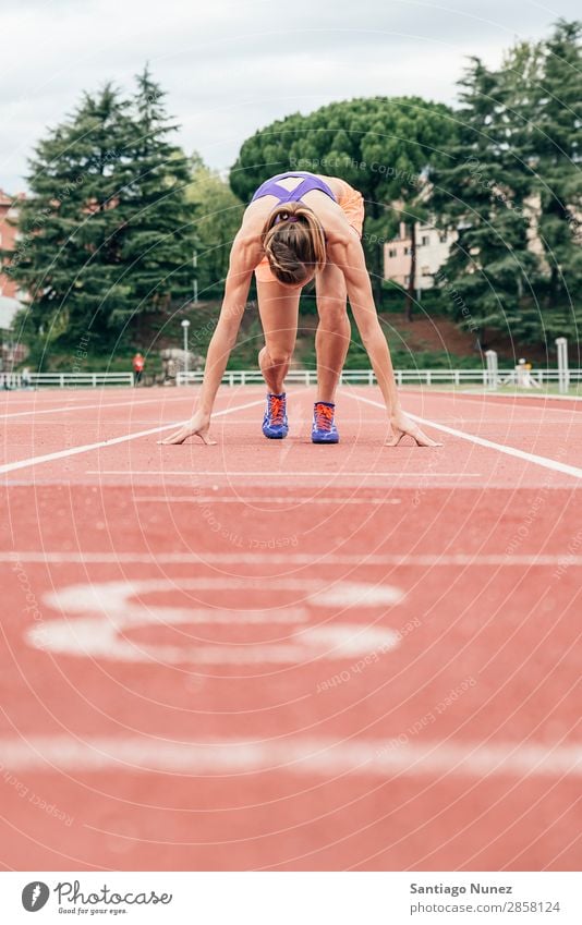 Frau macht sich bereit, mit dem Laufen zu beginnen. Athlet Leichtathletik schwarz Block Blöcke Bekleidung selbstbewußt Textfreiraum üben Feld bekommend