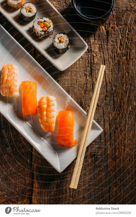 Sushi Maki Rollen und Sashimi auf Holzuntergrund asiatisch Avocado Essstäbchen Speise Fisch Lebensmittel Ingwer Japaner maki Nigiri nori roh Reis Lachs