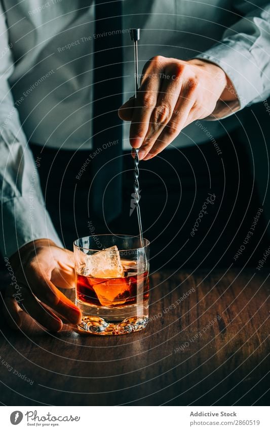 Ein Glas Whiskey auf einem Holztisch Alkohol Amber Hintergrundbild Bar Barmann Barkeeper Getränk Flasche Bourbon Weinbrand Cognac trinken gold Hand Eis