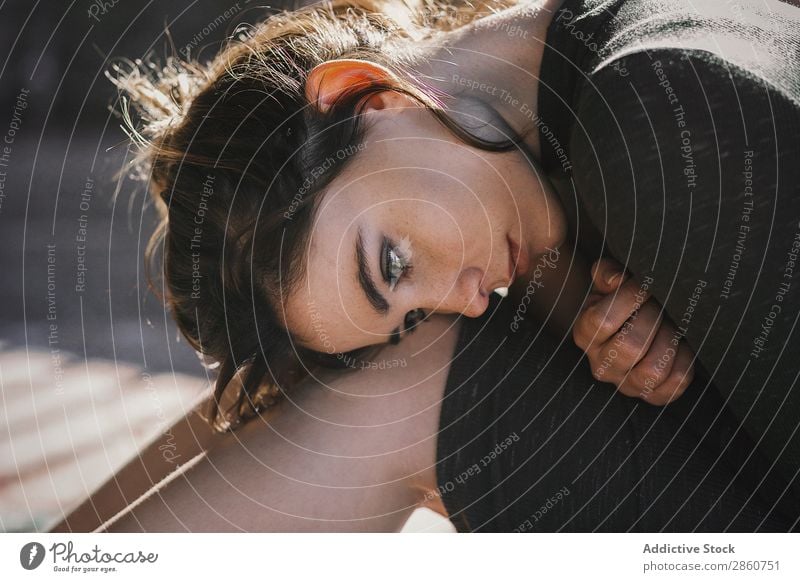 Sinnliches Mädchen sitzt auf dem Boden in der Sonne. Frau Schatten genießen Sonnenlicht Streifen Hochsitz sitzen Etage Körperhaltung Morgen Kleid Barfuß hell