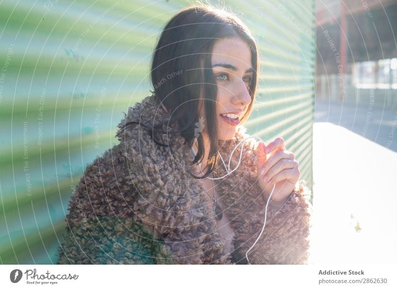 Trendige Frau mit Smartphone an der Wand PDA benutzend Straße Großstadt anlehnen Stil Jugendliche Sonnenstrahlen Tag genießen trendy Mode Outfit Außenseite