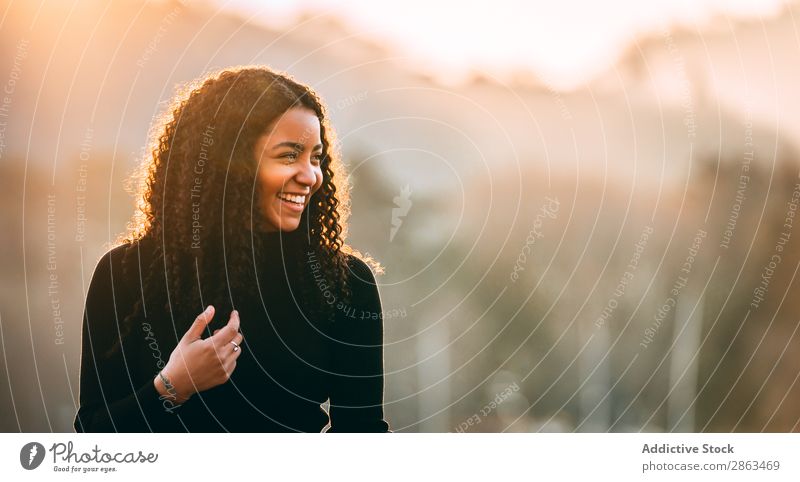 Lächelnde schwarze Frau mit lockigem Haar Afroamerikaner Behaarung attraktiv Glück Jugendliche Dame Lifestyle trendy Mode schön Model dünn urwüchsig Freude