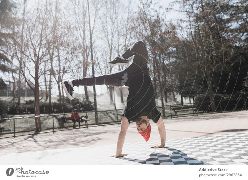 Mann tanzt Breakdance im Park Breakdancer Schönes Wetter Tanzen üben Stil sportlich Jeanshose Jugendliche Typ Sport Fitness Flexibilität Spielplatz Yoga