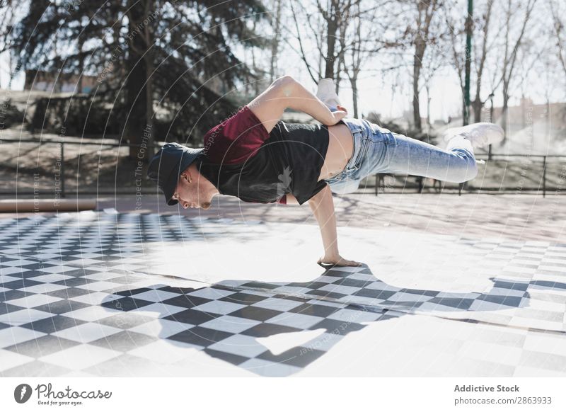 Mann tanzt Breakdance im Park Breakdancer Schönes Wetter Tanzen üben Stil sportlich Jeanshose Jugendliche Typ Sport Fitness Flexibilität Spielplatz Yoga