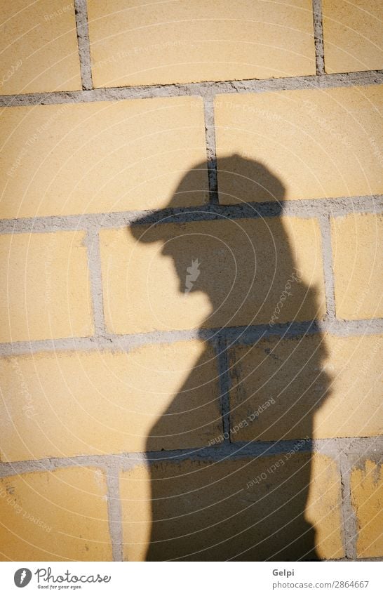 Schatten einer Frau mit Hut an der Wand Design Dekoration & Verzierung Tapete Erwachsene Felsen Gebäude Architektur Stein Beton alt bauen hell natürlich stark