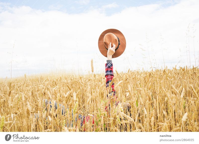 Hand hält einen Cowboyhut über einem Weizenfeld. Bioprodukte Lifestyle Stil Design Freude Glück schön Wellness Leben Wohlgefühl Zufriedenheit Erholung Freiheit