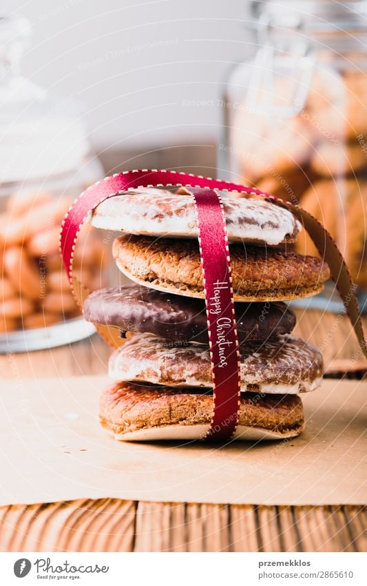 Ein paar Lebkuchenplätzchen in rot eingewickelt auf Holztisch Dessert Ernährung Essen Diät Glück Tisch Schnur genießen lecker braun Weihnachten backen Bäckerei