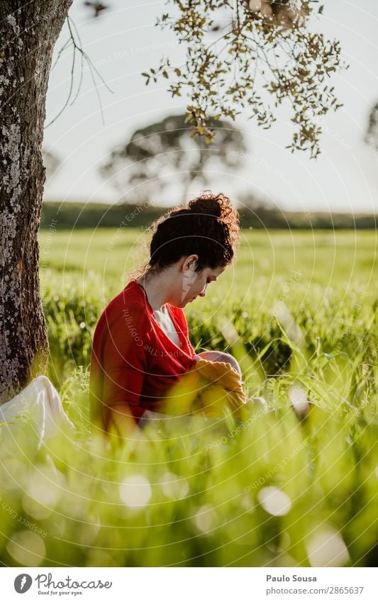 Mutter stillen Baby in der Natur Lifestyle Mensch Kind Kleinkind Junge Frau Jugendliche Erwachsene 2 0-12 Monate 18-30 Jahre Frühling Schönes Wetter Baum