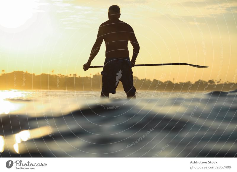 Mann mit Paddel auf dem Surfbrett zwischen Wellenwasser bei Sonnenuntergang Wasser Oberfläche Sport Bali Indonesien Silhouette Himmel Meer Himmel (Jenseits)