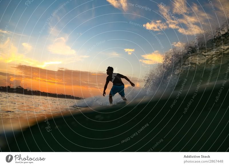 Mann auf dem Surfbrett auf winkendem Wasser bei Sonnenuntergang Oberfläche Sport Bali Indonesien platschen Surfen Himmel Meer Himmel (Jenseits) Abend