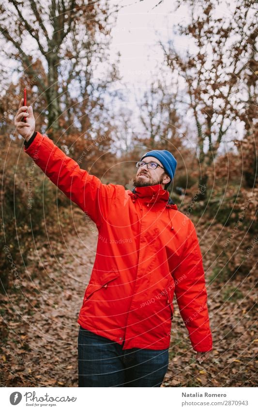 Junger Mann mitten im Wald sucht nach Deckung. Lifestyle schön Ferien & Urlaub & Reisen Abenteuer wandern Telefon Bildschirm Technik & Technologie Mensch