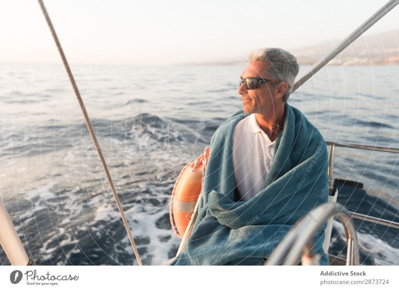 Lächelnder Mann im Handtuch auf der Yacht auf dem Wasser Jacht Erwachsene Meer fliegend Schönes Wetter Wasserfahrzeug teuer Sonnenbrille aussruhen positiv