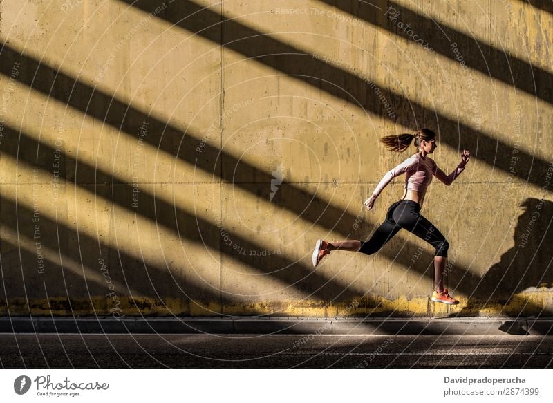 Junge, fitte, blonde Frau, die auf der Straße springt. springen rennen üben Fitness ausarbeiten Lifestyle Bewegung Aktion Joggen Profil horizontal sportlich