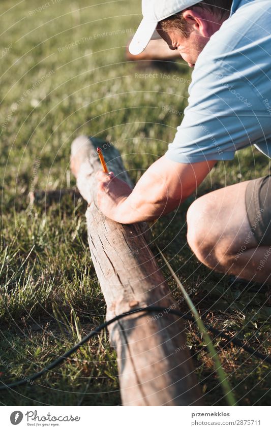 Der Mensch setzt Zeichen mit Bleistift im Garten Sommer Arbeit & Erwerbstätigkeit Handwerk Werkzeug Mann Erwachsene Gras Gebäude Hut Holz Stahl weiß Schutz