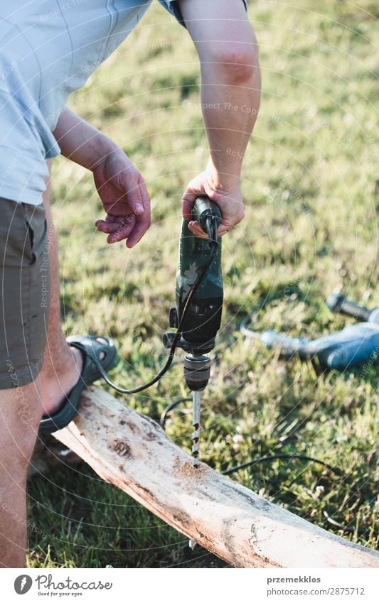 Mann bohrt Loch in Holz bei der Gartenarbeit Sommer Haus Arbeit & Erwerbstätigkeit Handwerk Werkzeug Mensch Erwachsene Gras Gebäude 35-40 Jahre Kunstgewerbler