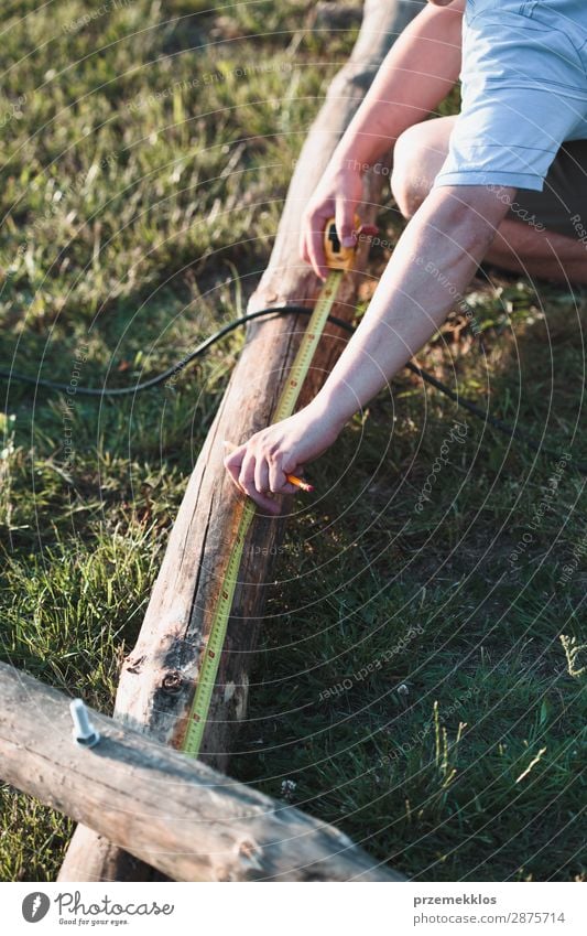 Mann mit Stahlbandmaßstab Sommer Garten Arbeit & Erwerbstätigkeit Handwerk Werkzeug Mensch Erwachsene Gras Gebäude Holz weiß Schutz Präzision 35-40 Jahre