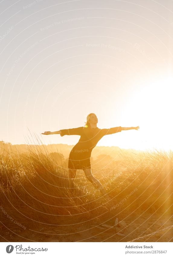 Frau, die bei Sonnenuntergang zwischen den Feldern posiert. Himmel blau Jugendliche Wiese Gras Lifestyle regenarm Freizeit & Hobby Natur schön Körperhaltung