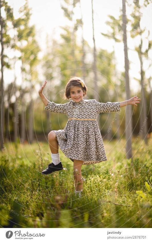 Kleines Mädchen, das auf einem Feld in der Natur spazieren geht und ein schönes Kleid trägt. Lifestyle Freude Glück Spielen Sommer Kind Mensch Baby Frau