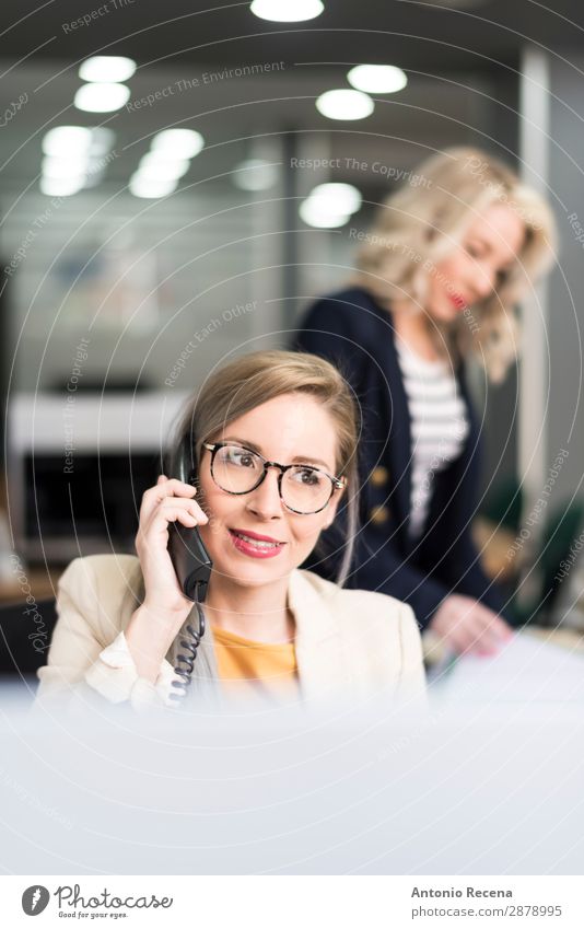 Attraktive 30er Jahre Frau im Büro mit Telefon elegant Schreibtisch Arbeit & Erwerbstätigkeit Arbeitsplatz Business Unternehmen Mensch Erwachsene Anzug Lächeln