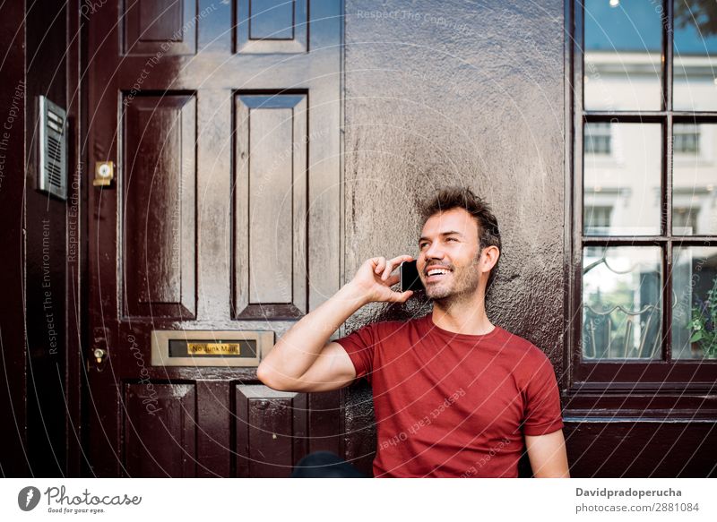 Mann sitzt auf einer Bank auf einem schönen kastanienbraunen Hintergrund. Handy Kaukasier heiter Gebäude Jugendliche Architektur Technik & Technologie