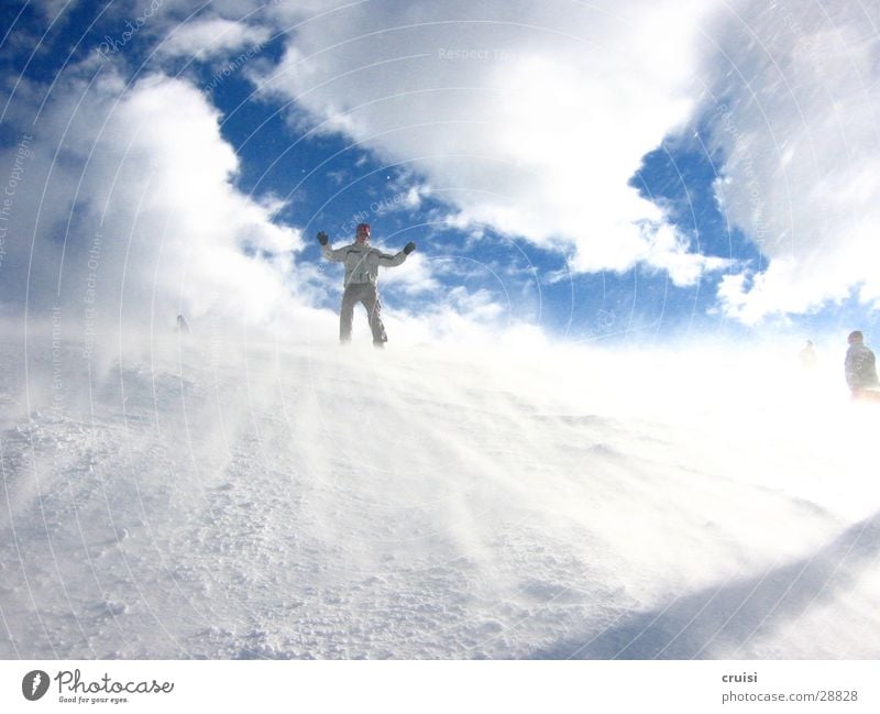 Schneesturm Sturm weiß kalt Winter Sport Rutscher Happy Slider Wind Eis Snowboarder Snowboarding abwärts Wolkenhimmel Hände hoch Außenaufnahme Farbfoto