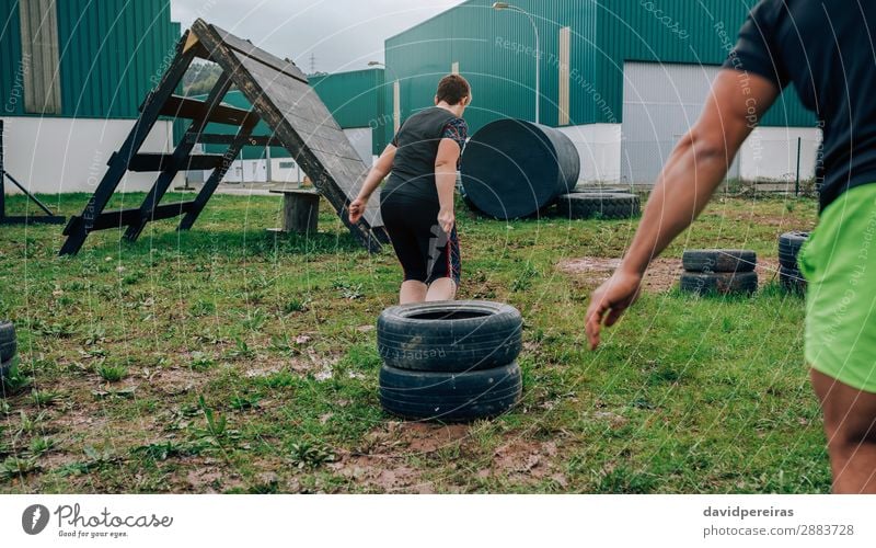 Teilnehmer an einem Hindernisparcours mit Schlepprädern Sport Mensch Frau Erwachsene Mann Gras authentisch stark Kraft anstrengen Hindernisrennen schleppend Rad