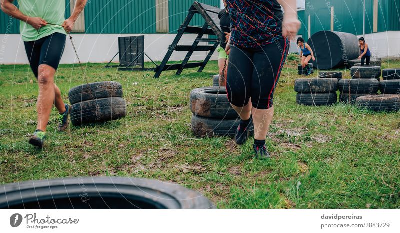 Gruppe im Hindernisparcours, die Räder zieht Freude Sport Mensch Frau Erwachsene Mann Gras Lächeln authentisch stark Kraft anstrengen Hindernisrennen schleppend