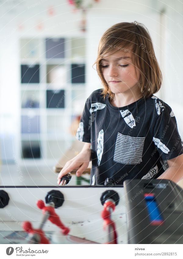 langhaariger Junge spiel am Kickertisch Freizeit & Hobby Spielen Kinderspiel Tischfußball Sport Fußball maskulin 1 Mensch 8-13 Jahre Kindheit T-Shirt brünett