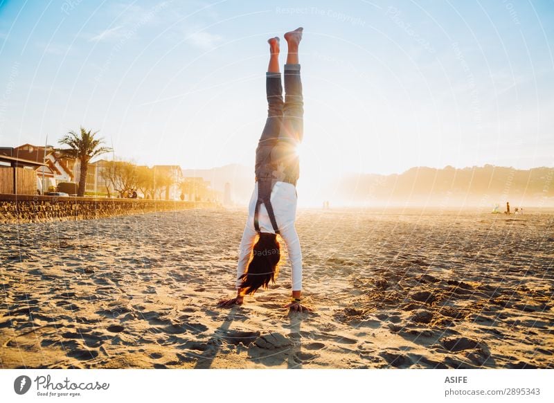 Kleines Mädchen steht auf Händen am Strand bei Sonnenuntergang. Freude Glück schön Spielen Ferien & Urlaub & Reisen Freiheit Sommer Meer Kind Natur Sand Himmel