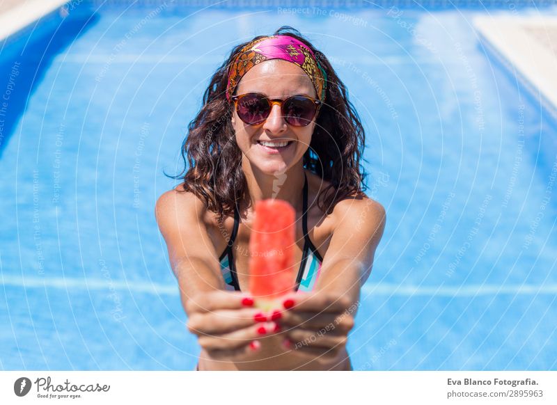 schöne junge Frau, die ein Stück Wassermelone hält. Frucht Diät Saft Freude Glück Haare & Frisuren Gesicht Maniküre Lippenstift Schwimmbad