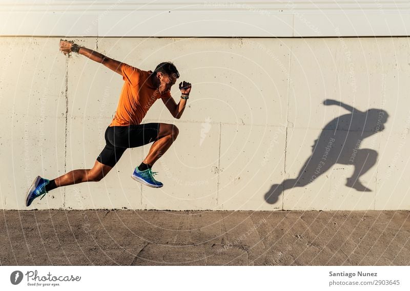 Ein gutaussehender Mann, der in der Stadt herumläuft. rennen Joggen Läufer Straße Großstadt Athlet Geschwindigkeit Fitness Lifestyle Jugendliche Aktion Schatten