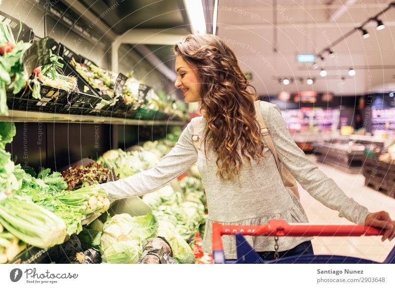 Schöne Frau, die sich im Supermarkt einen Salat holt. kaufen Jugendliche Lebensmittel Markt benutzend Mensch Lächeln Karre schön hübsch Lifestyle Kunde nehmen