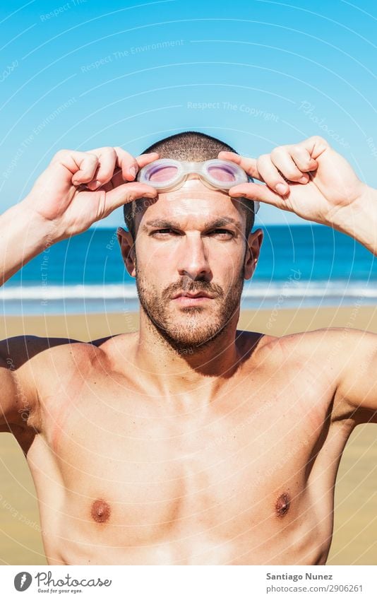 gutaussehender Schwimmer, der eine Brille aufsetzt. Bauchmuskeln attraktiv Strand schwarz Körper Kaukasier Taucher tauchen üben sportlich Fitness Brillenträger