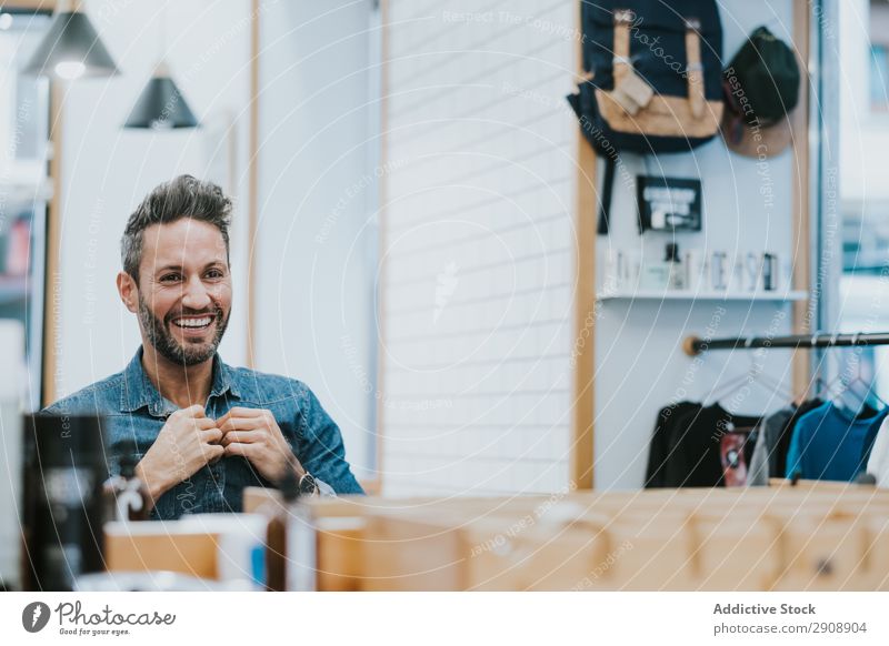 Mann schaut in den Spiegel und berührt den Bart im Salon. Vollbart Überprüfung Reflexion & Spiegelung gutaussehend Stil professionell berühren Blick Mode