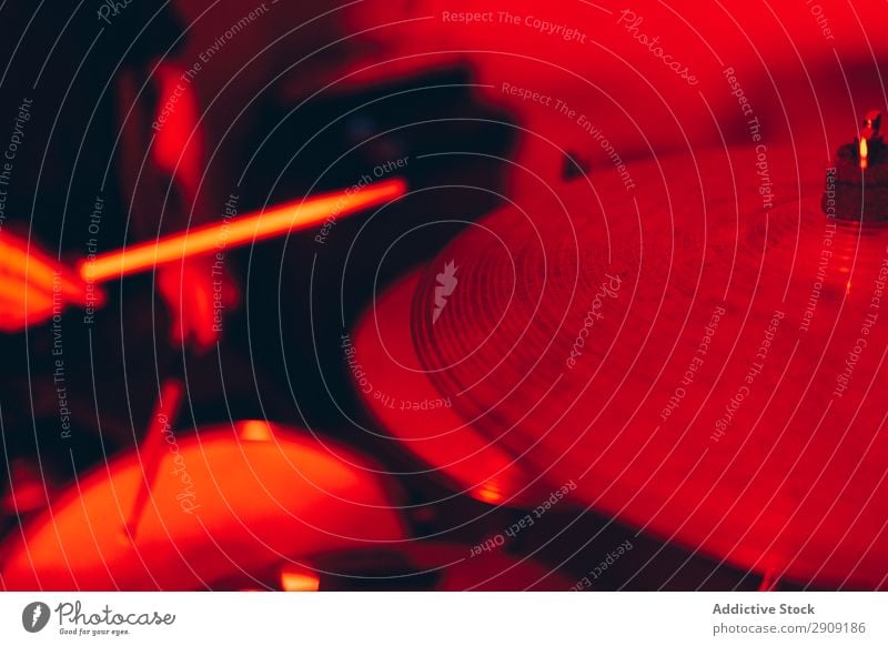 Anonymer Mann mit Trommelstöcken, die auf Trommeln in Rötung spielen. Trommelschlegel Hand Röte rot Licht Spielen Studioaufnahme Musik professionell Jugendliche