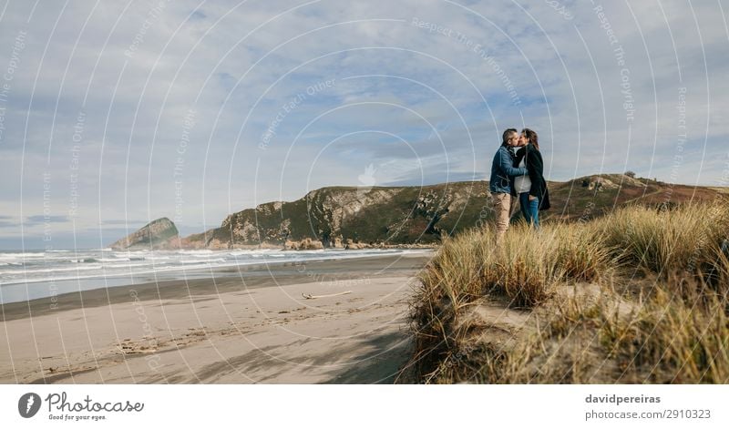 Ein Paar küsst sich am Strand. Lifestyle ruhig Freizeit & Hobby Meer Wellen Winter Frau Erwachsene Mann Eltern Familie & Verwandtschaft Natur Landschaft Sand