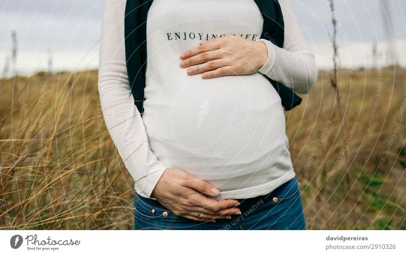 Schwangere Frau, die ihren Bauch streichelt. Lifestyle Freude Glück Freizeit & Hobby Mensch Baby Erwachsene Mutter Familie & Verwandtschaft Hand Natur