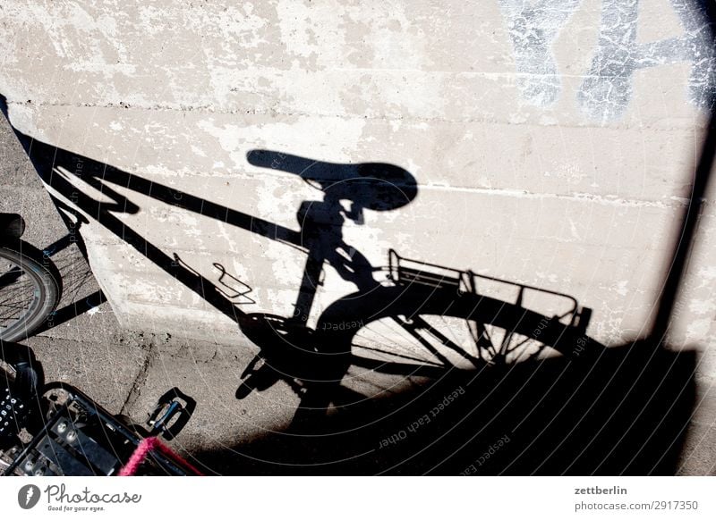 Fahrradschatten Fahrradtour Rad Abstellplatz Parkplatz Stellplatz stehen warten Fahrradsattel Gepäckablage Fahrradrahmen Licht Schatten Brandmauer hinterhaus