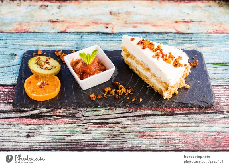 Vegane Kokostorte mit Krokant, Pflaumen & Obst Lebensmittel Frucht Kuchen Dessert Kaffeetrinken Slowfood mehrfarbig türkis Schiefer modern Holztisch Torte